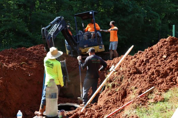 Construction of septic system with excavation and workers