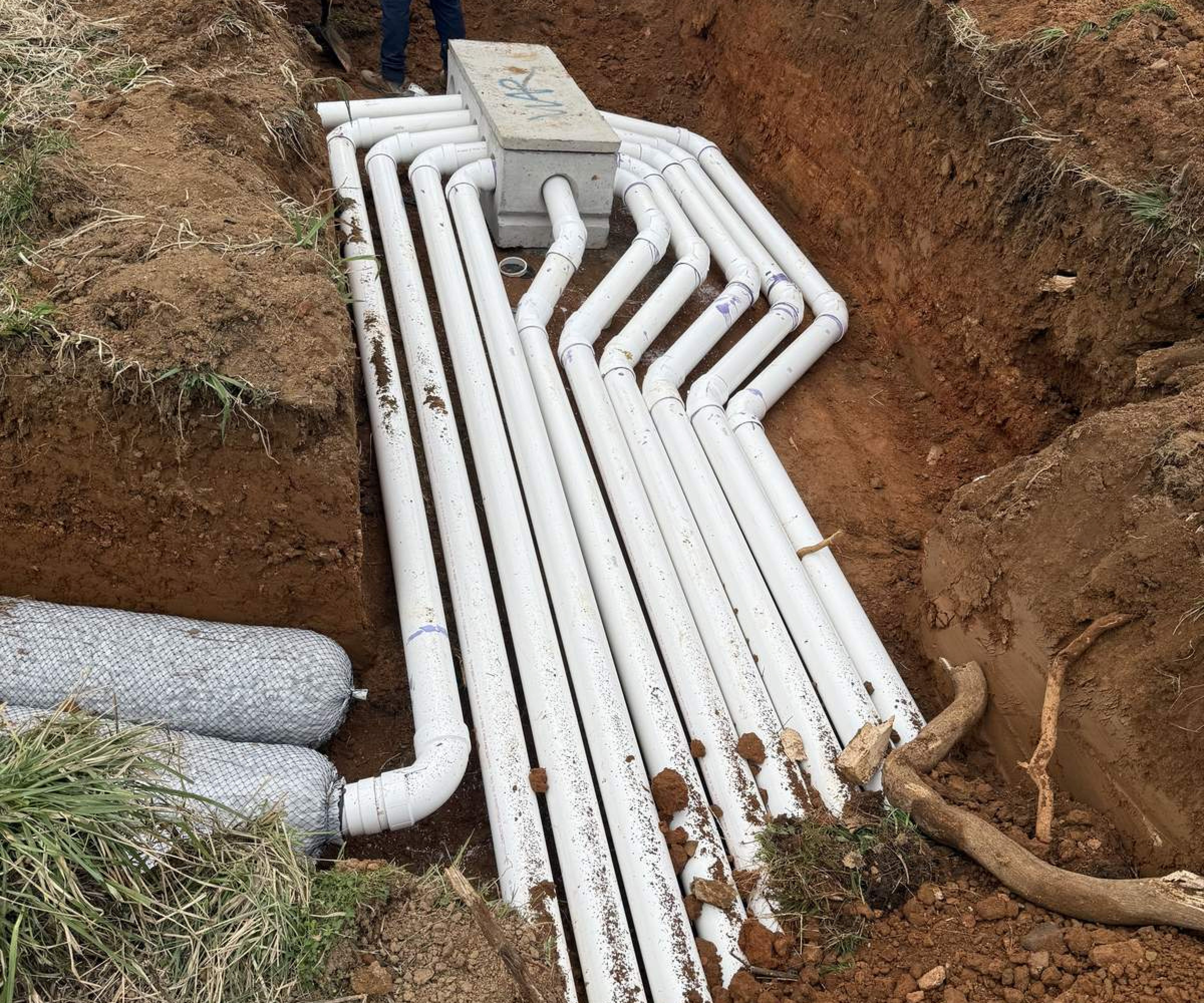 Septic pipe installation in digging site with worker